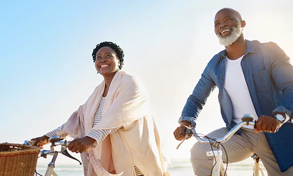 Hemorrhoid Treatment - photo of an older couple riding bikes on a beach